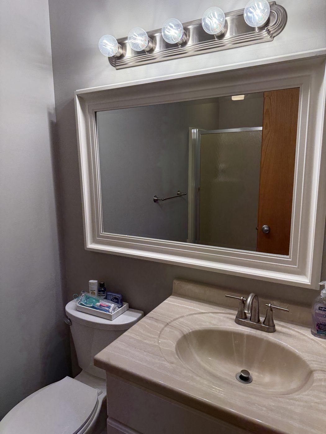 The private restroom with vanity, mirror, and complimentary toiletries